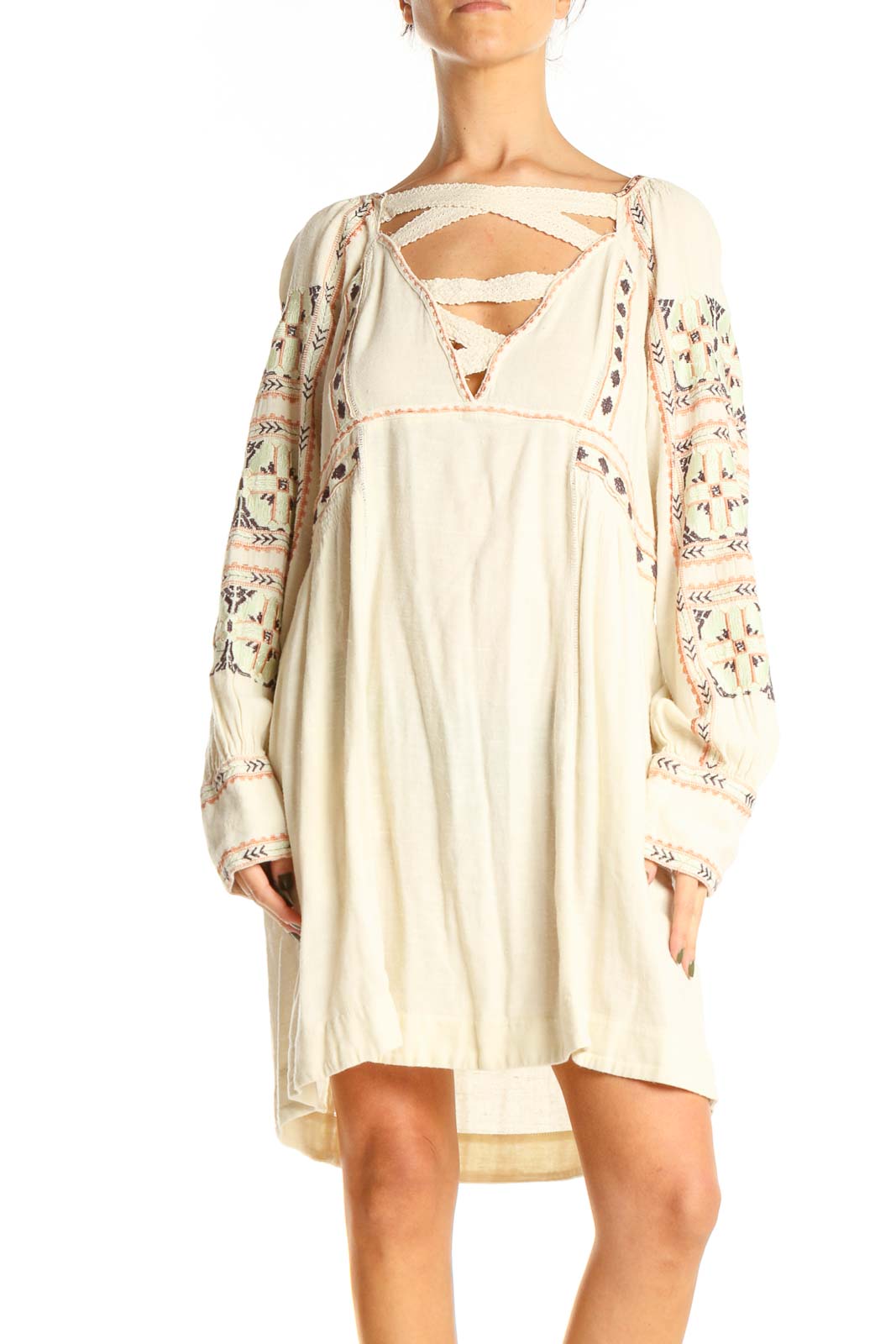 Front view of cream Free People mini dress with embroidered sleeves and crisscross neckline