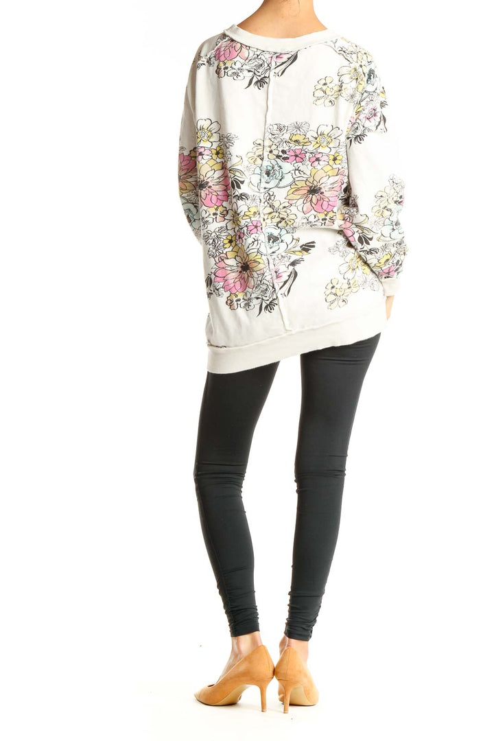 Back view of Free People white oversized sweatshirt showing full floral print design