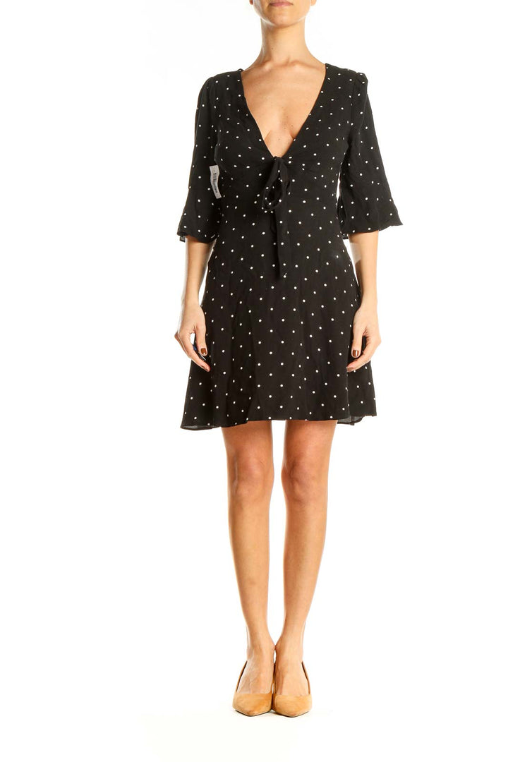 Front view of Free People black polka dot mini dress with V-neck and tie detail