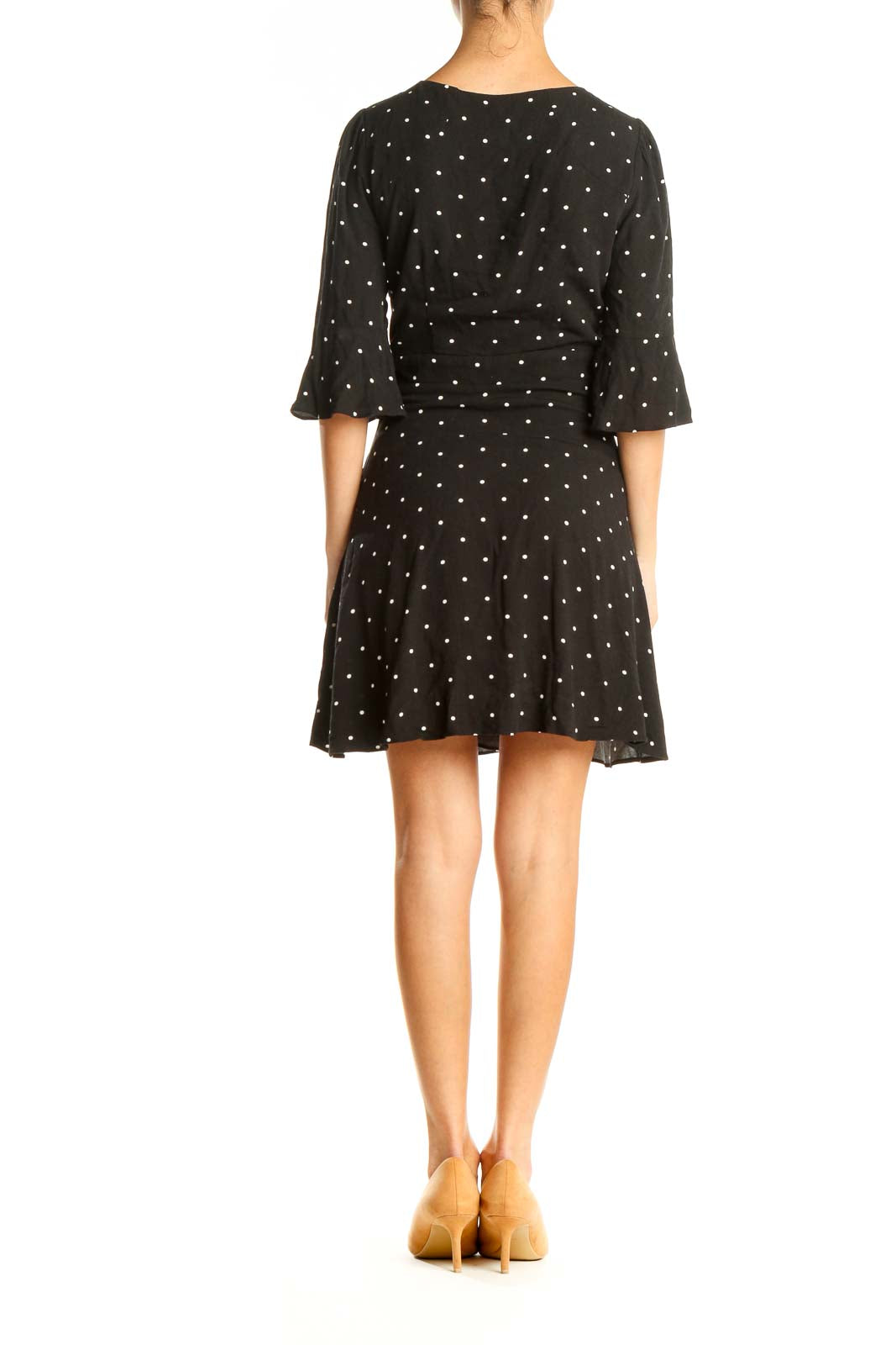 Back view of Free People black polka dot mini dress showing flared skirt and three-quarter sleeves