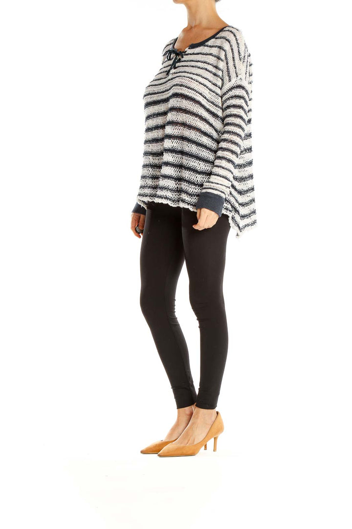 Front view of Free People white and black striped oversized knit sweater with toggle closures