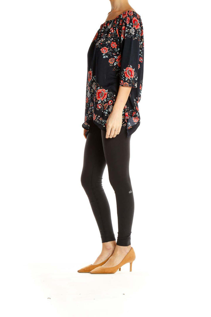 Front view of ECI black off-shoulder top with red floral print