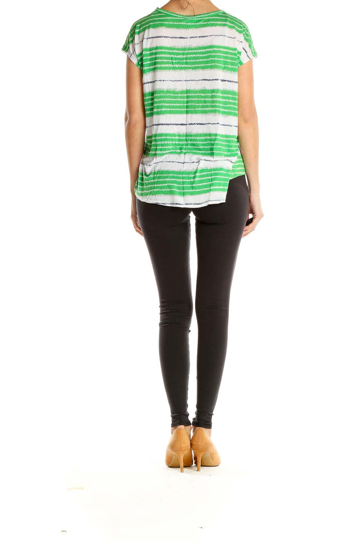 Side view of model wearing MICHAEL Michael Kors green and white striped top with black leggings