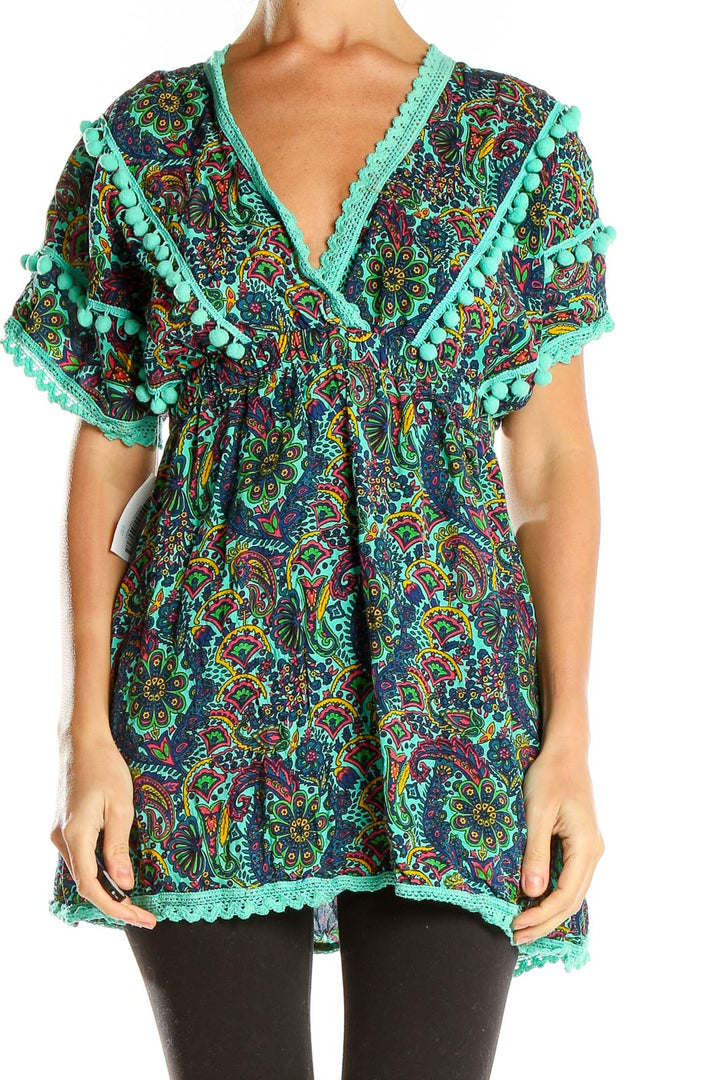 Front view of teal paisley tunic top with pom-pom trim