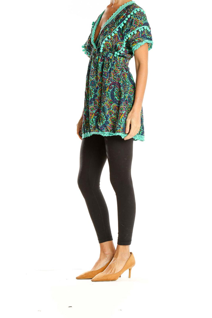 Front view of teal paisley tunic top with pom-pom trim