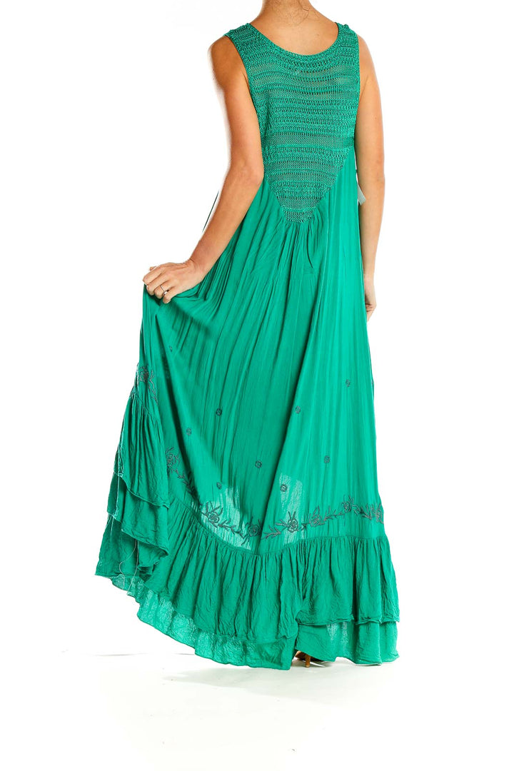 Back view of green Free People maxi dress showing tiered ruffle hem and embroidery details