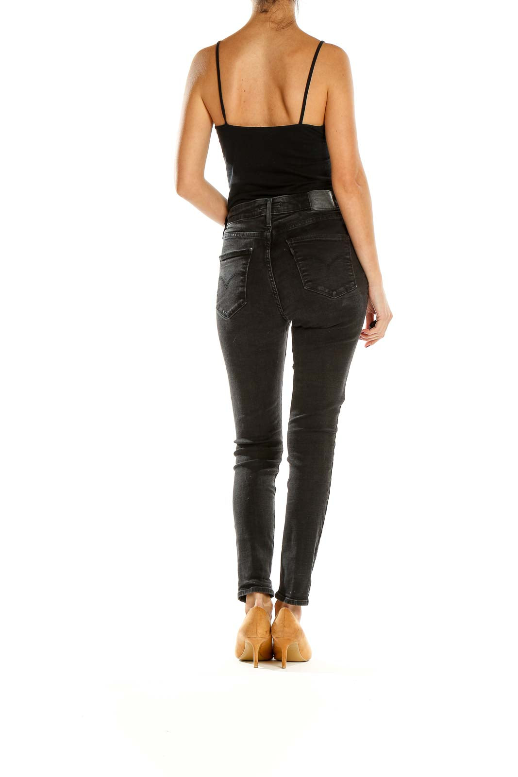 Side view of Levi's black high-waisted skinny jeans on model