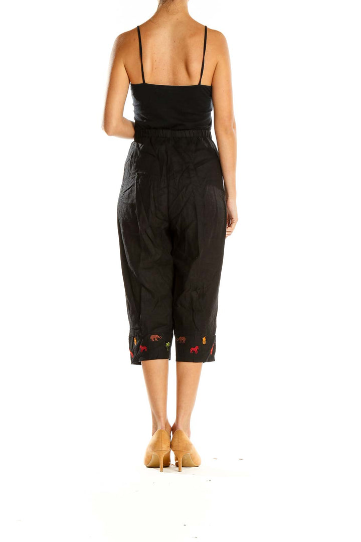 Side view of Studio Ease black capri pants showing embroidered design