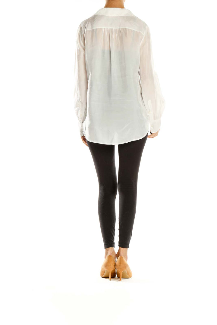 Side view of J.Crew white V-neck long sleeve blouse styled with black pants