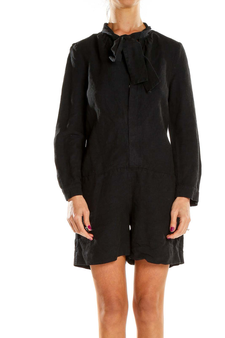 Front view of A.P.C. black long-sleeve romper with tie-neck detail