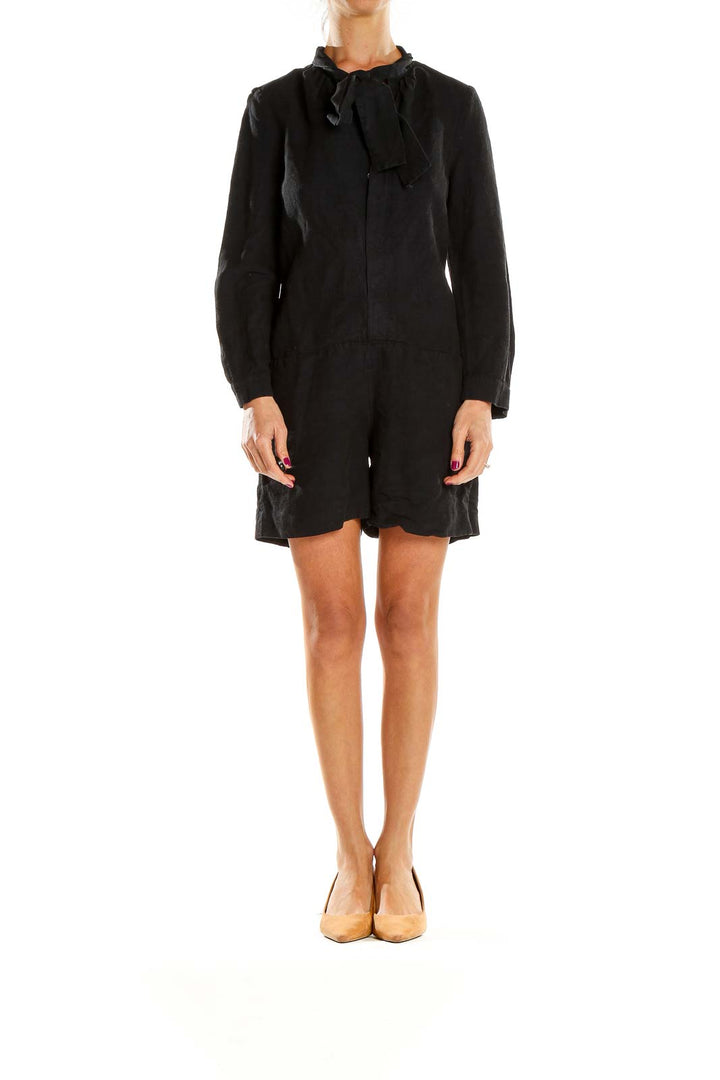 Front view of A.P.C. black long-sleeve romper with tie-neck detail