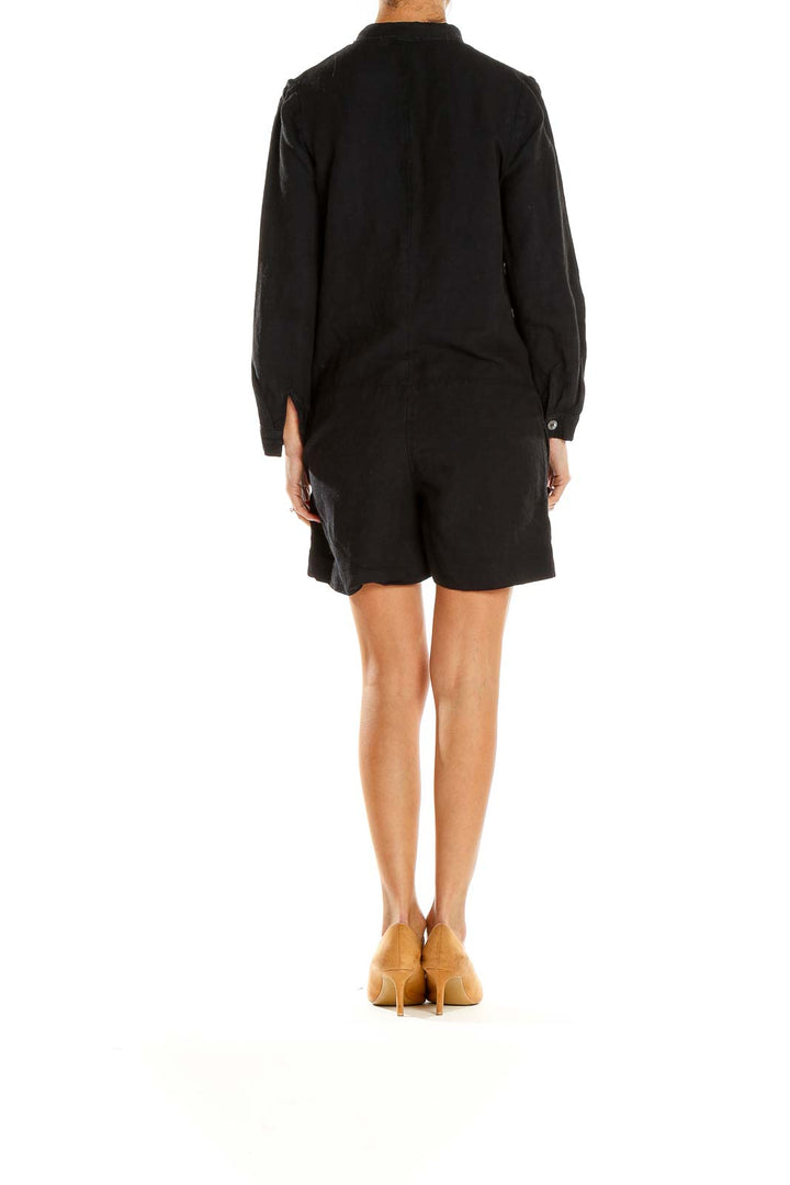 Side view of A.P.C. black long-sleeve romper showing silhouette