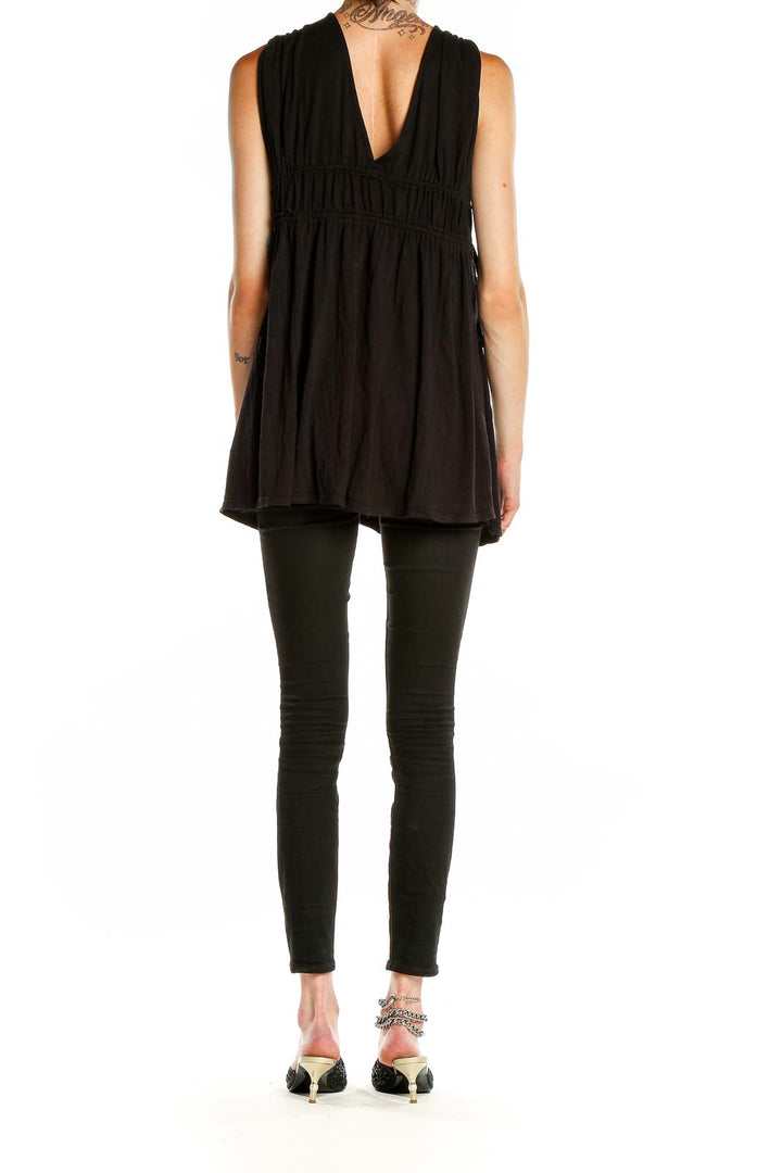 Back view of Free People black tunic top showing asymmetrical hem and flowy silhouette