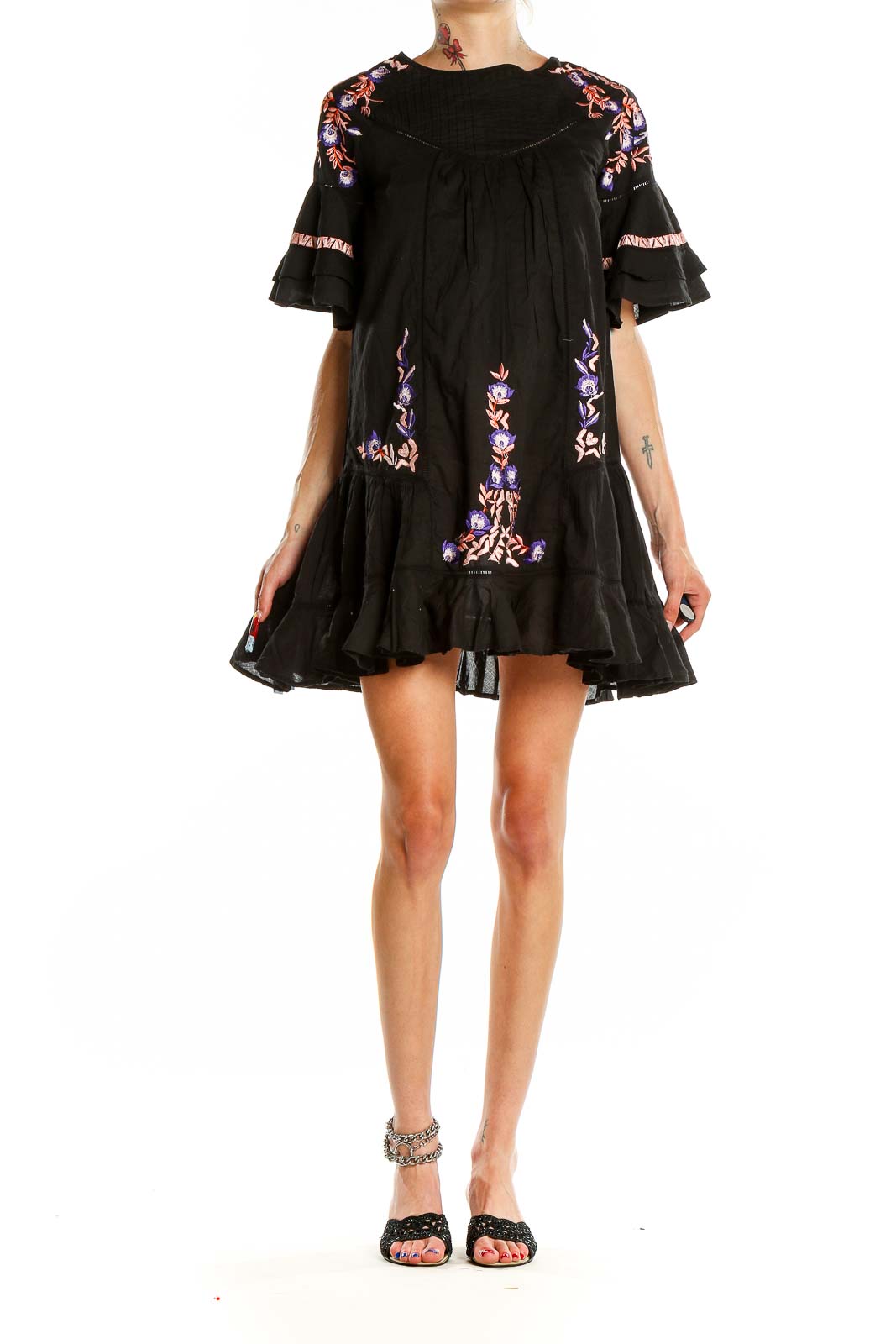 Front view of Free People black mini dress with colorful floral embroidery and ruffle details