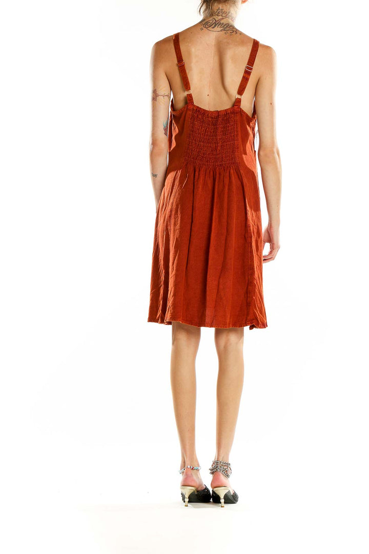 Back view of rust-colored JackPot sundress showing smocked panel and adjustable straps