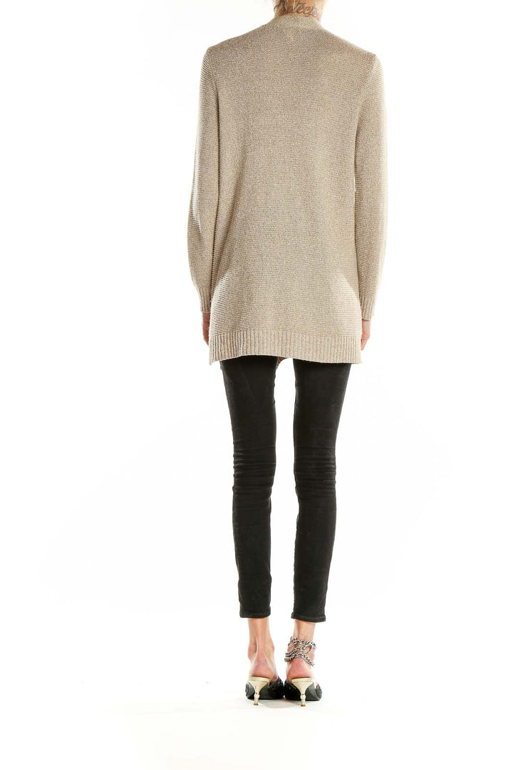 Back view of beige longline cardigan on model with black pants