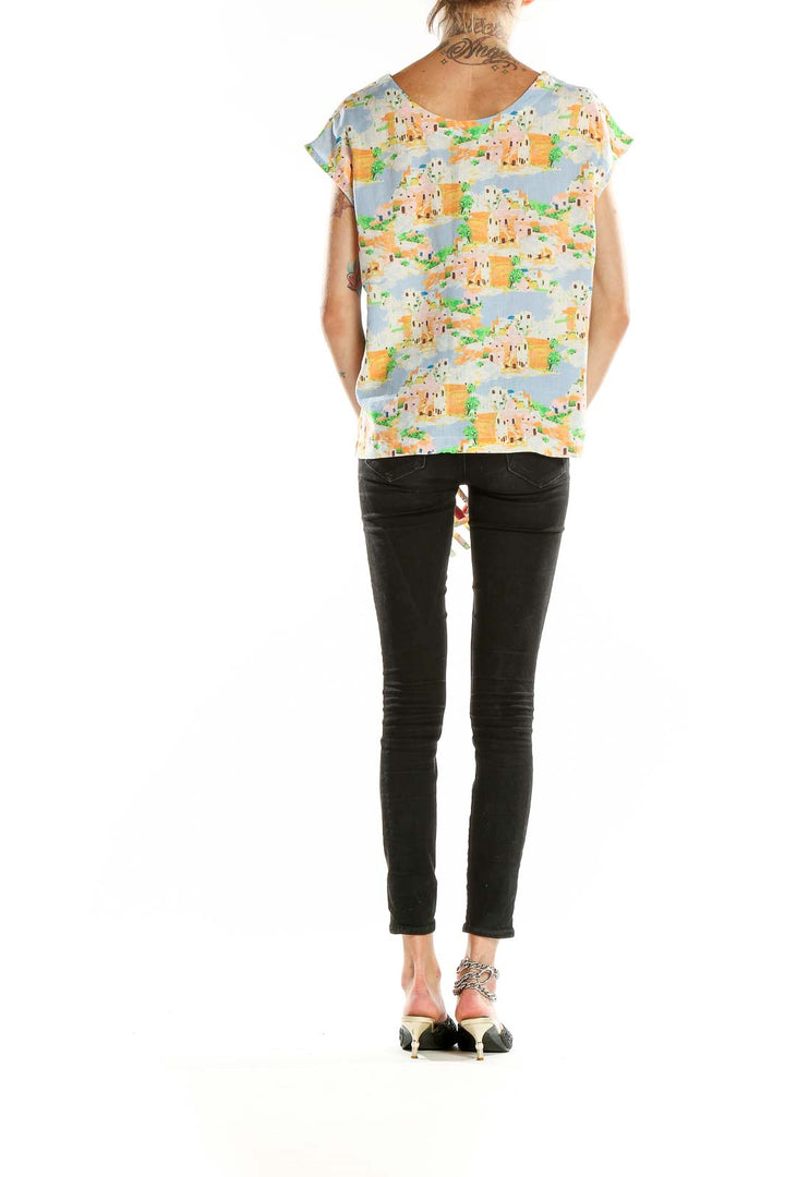 Back view of Cynthia Rowley pastel cityscape print blouse on model