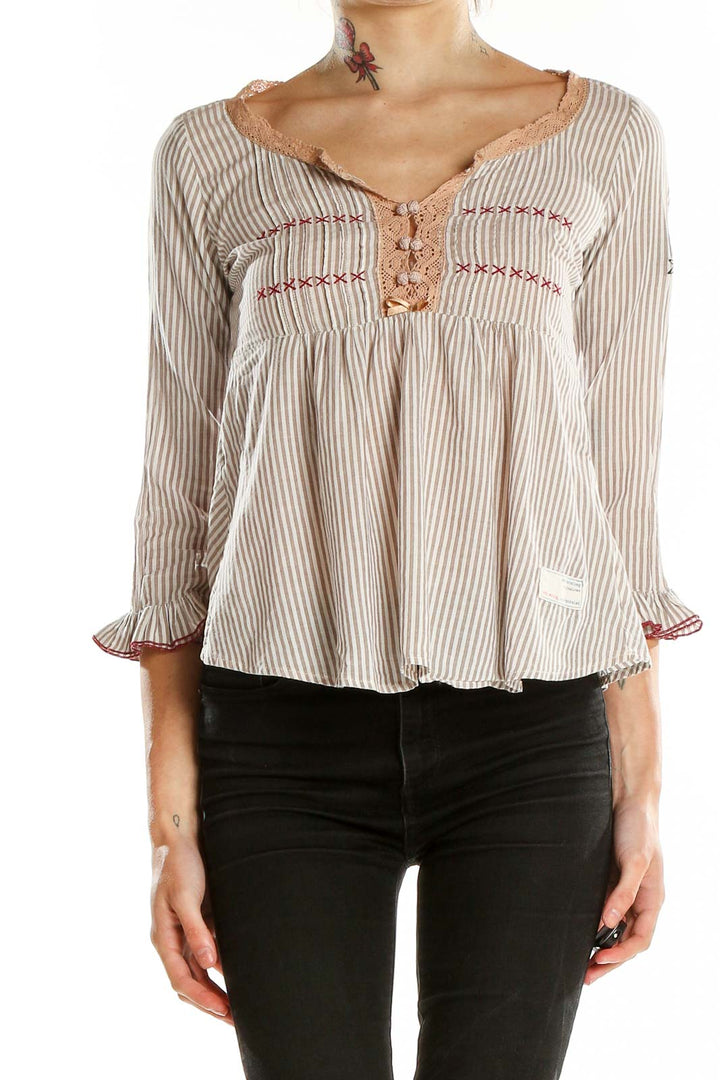 Front view of Odd Molly beige striped peasant blouse with lace trim and red embroidery