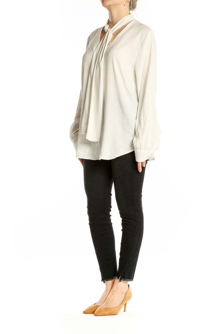 Front view of ivory Ann Taylor tie-neck blouse with long sleeves