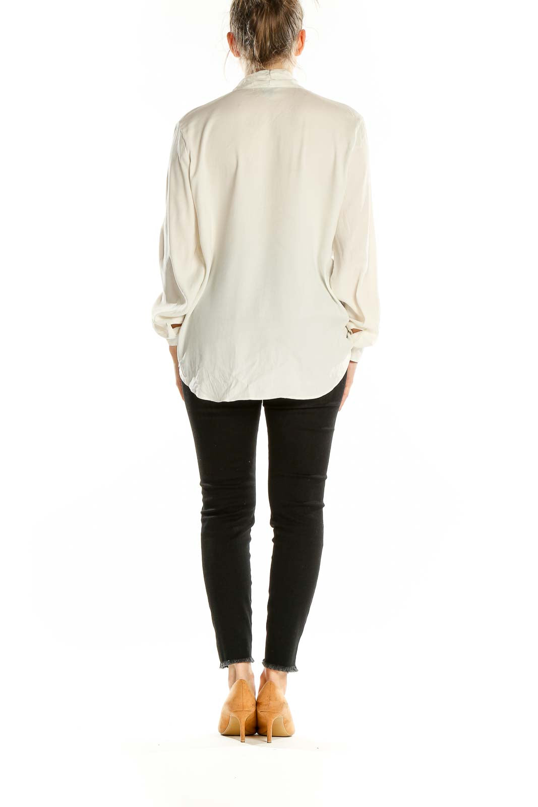 Back view of ivory Ann Taylor blouse on model with black pants