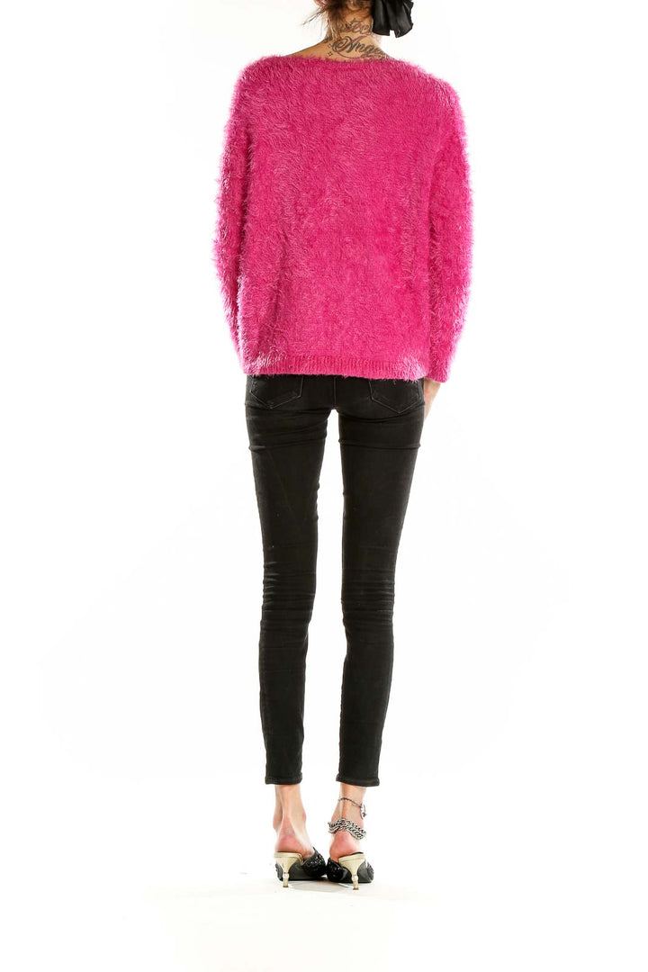 Side view of model wearing Vince Camuto hot pink fuzzy cropped sweater with black pants