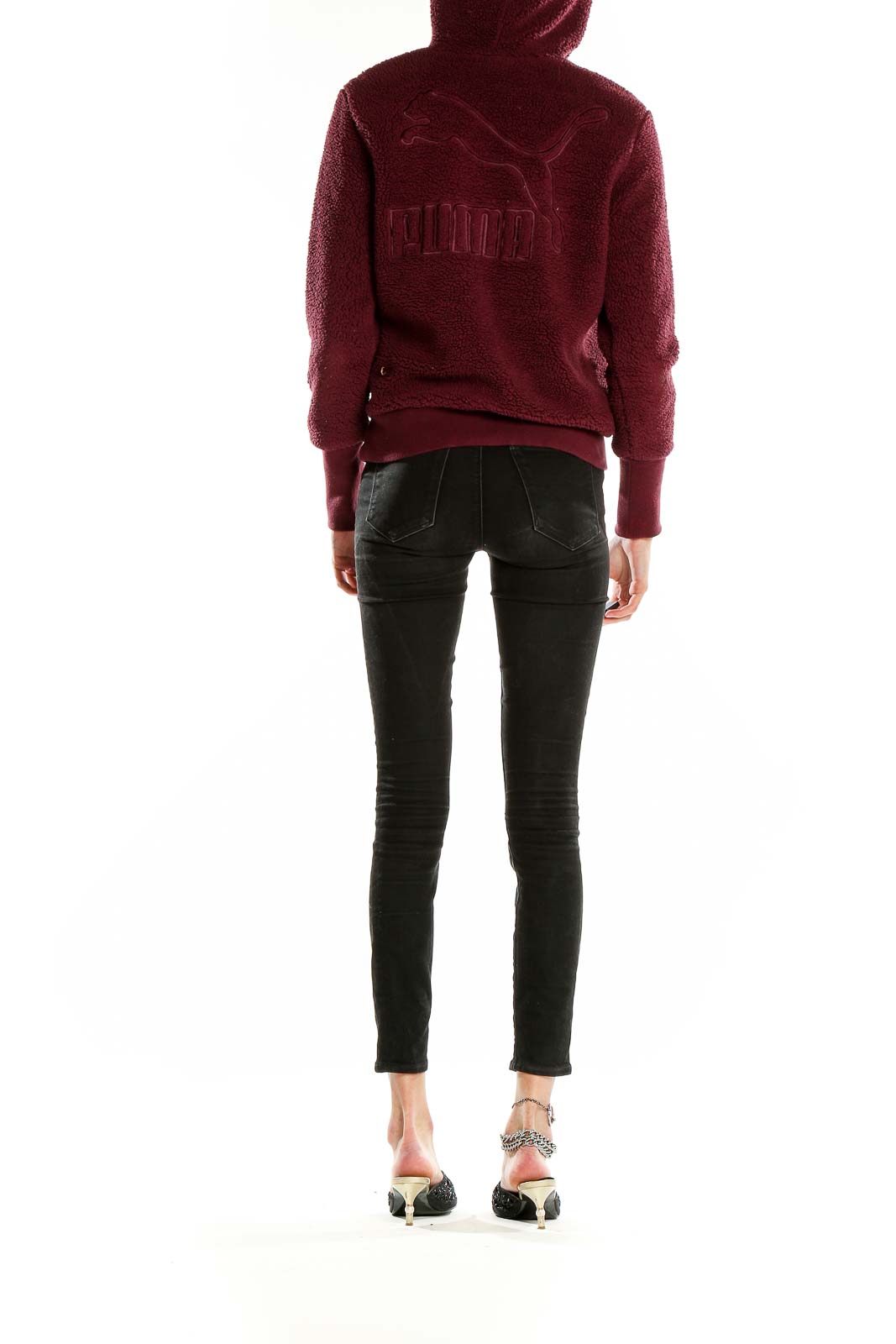 Side view of model wearing burgundy Puma fleece hoodie pullover with black pants