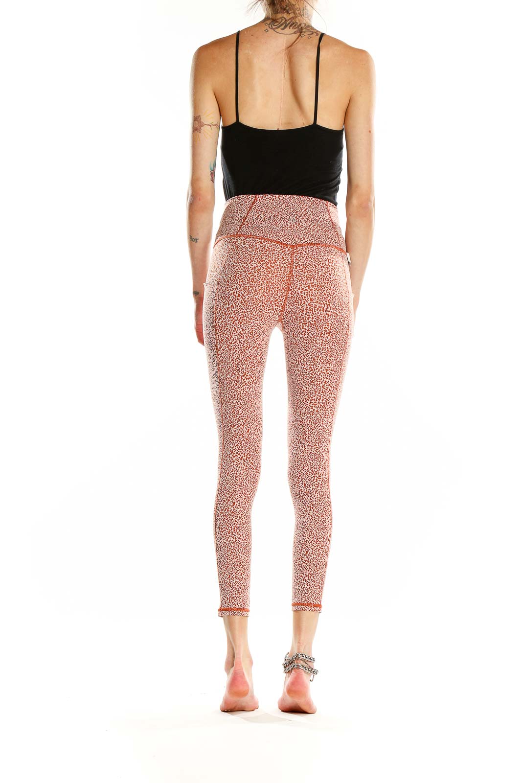 Side view of pink leopard print Athleta leggings on model with black top