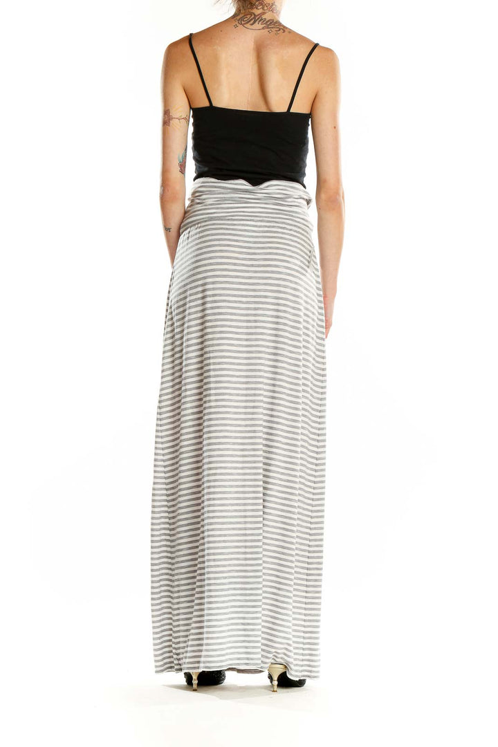 Side view of model wearing Max Studio gray and white striped maxi skirt with black top