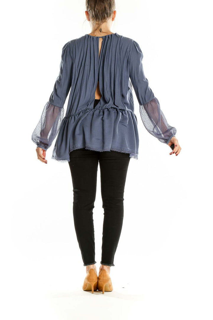 Back view of blue Free People peplum top showing open back design