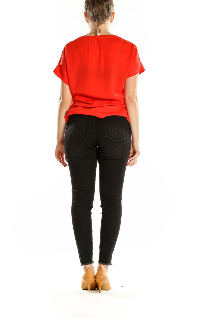 Back view of red short-sleeve Banana Republic blouse on model with black jeans