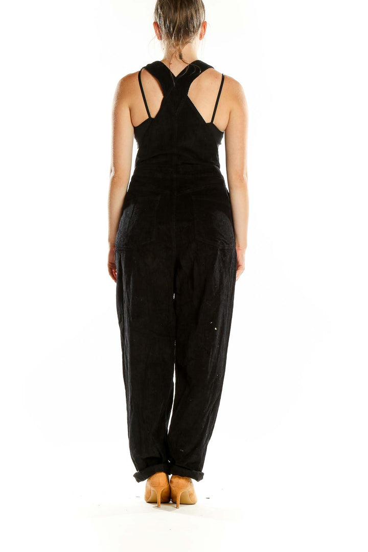 Back view of ASOS black overalls jumpsuit showing cross-back strap design