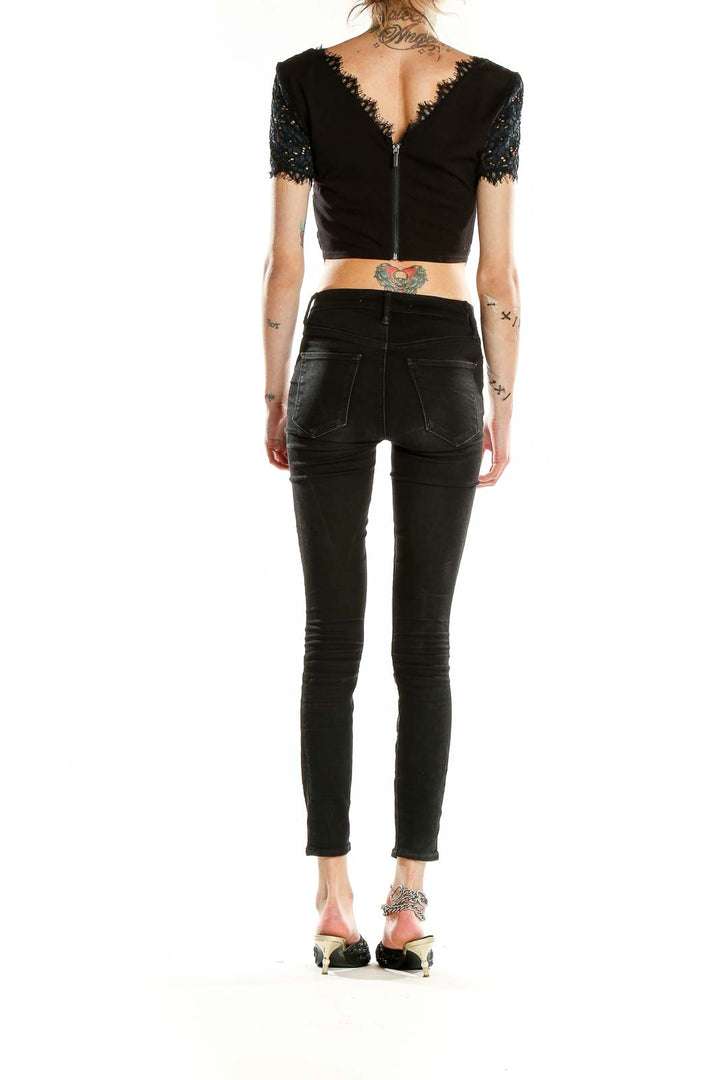 Back view of black lace crop top from Bebe with zipper closure