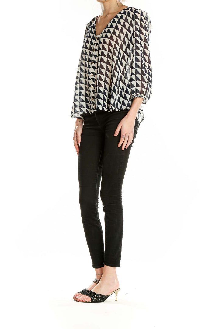 Front view of Lucy Paris black and white geometric print blouse with V-neck and button-front closure