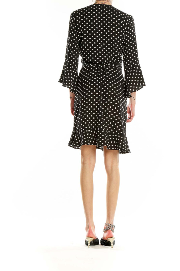 Back view of Veronicam black polka dot wrap dress showing flared design