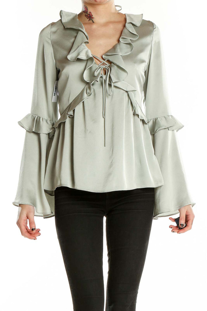 Front view of sage Molly Green blouse with ruffled V-neck and bell sleeves