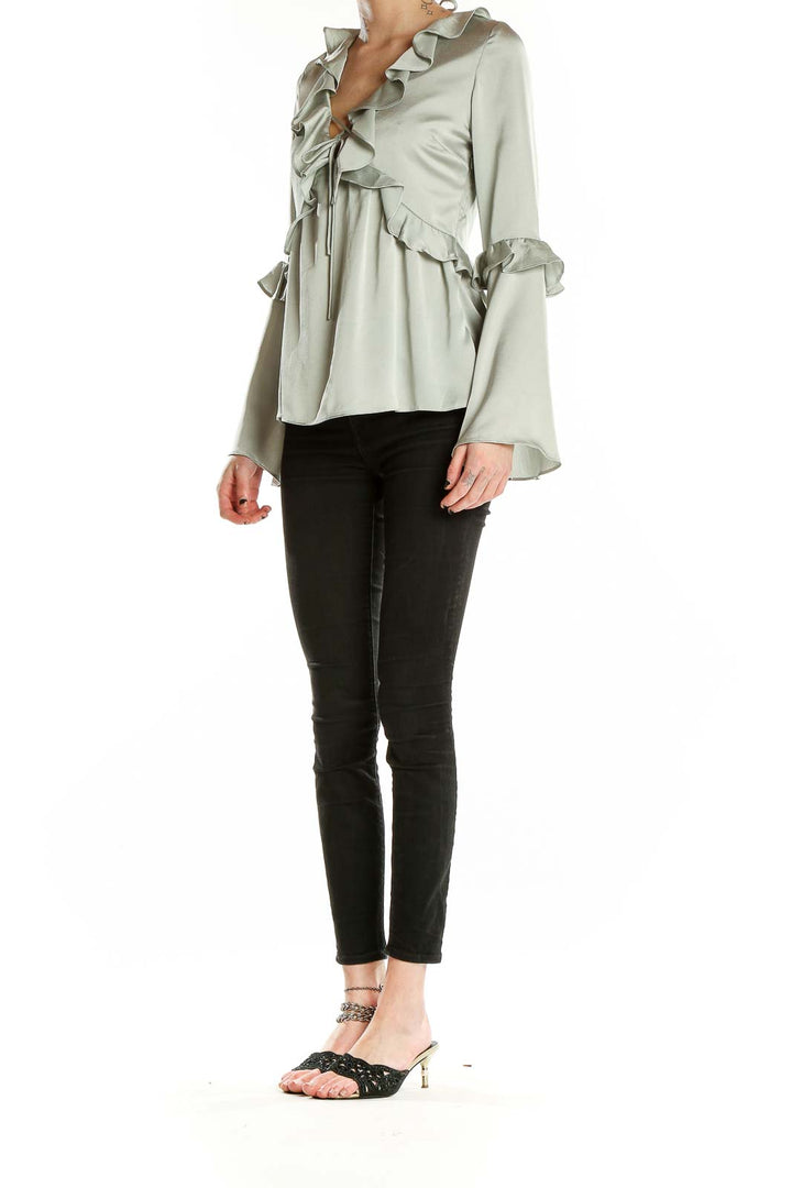 Front view of sage Molly Green blouse with ruffled V-neck and bell sleeves