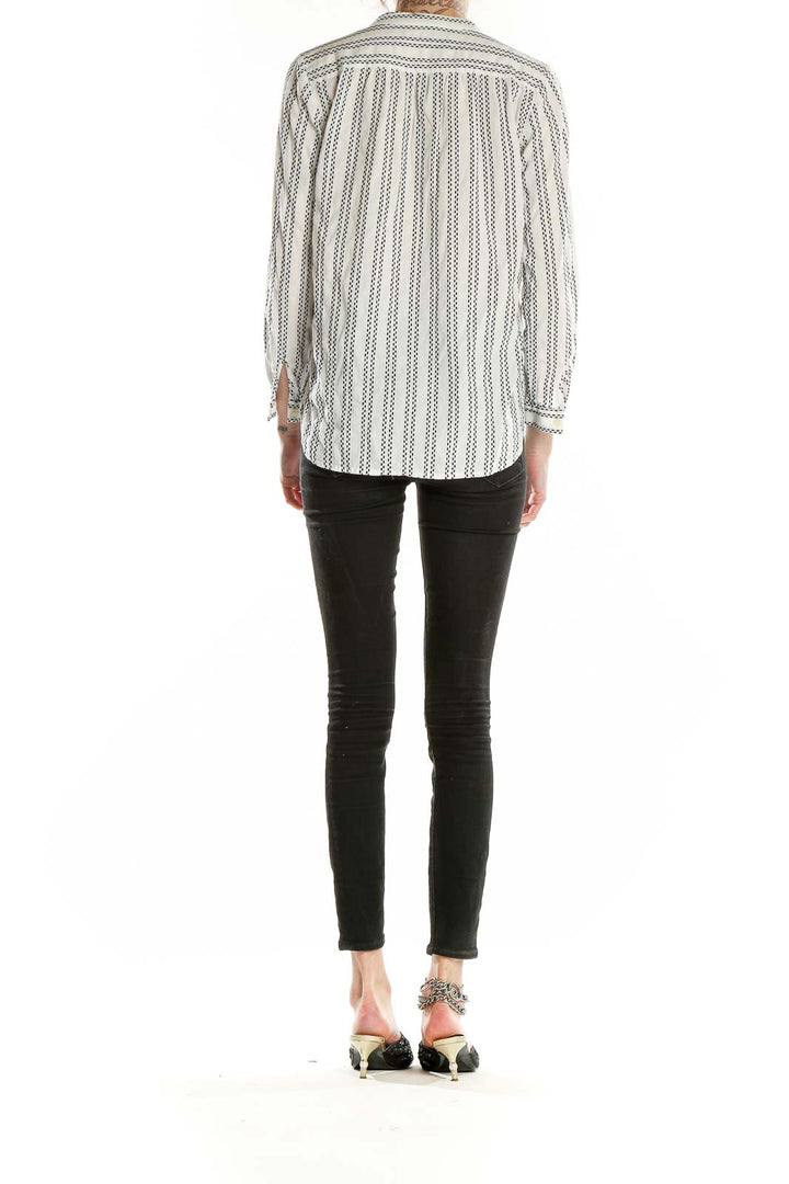 Back view of LOFT white striped V-neck blouse on model with black pants