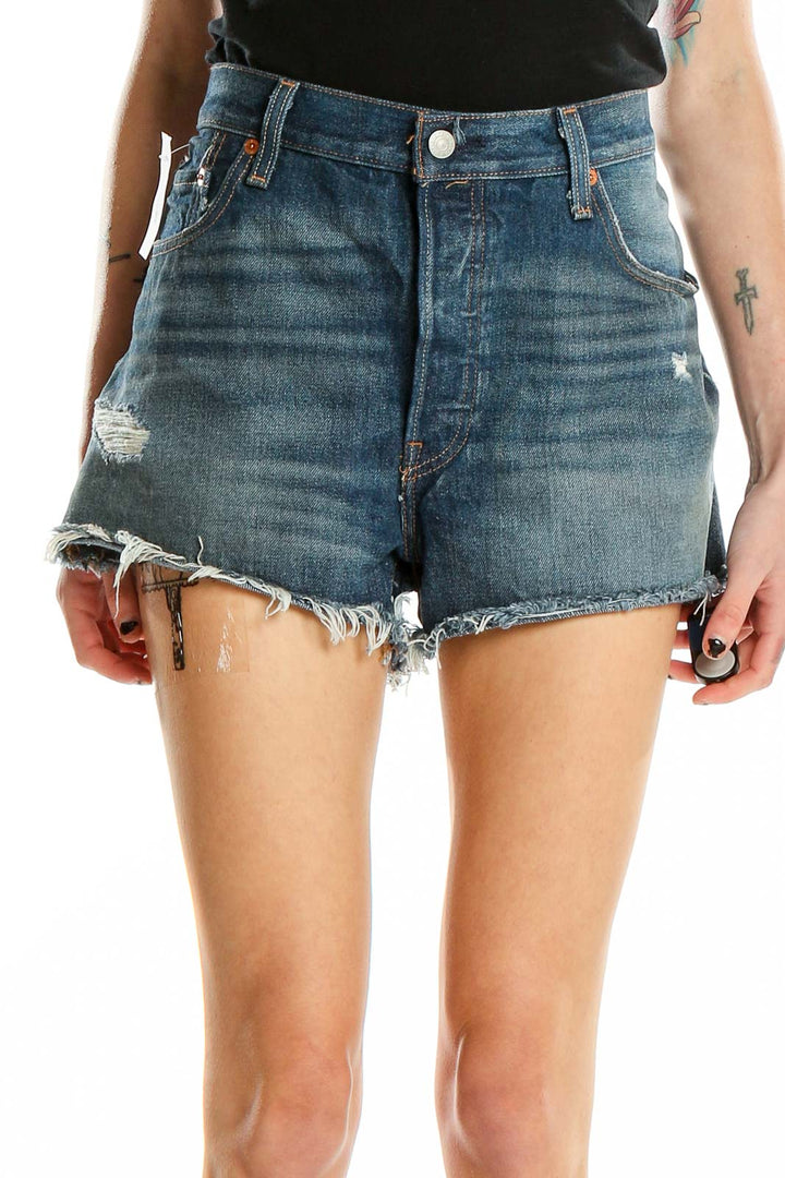 Front view of Levi's blue distressed denim cutoff shorts with raw hem