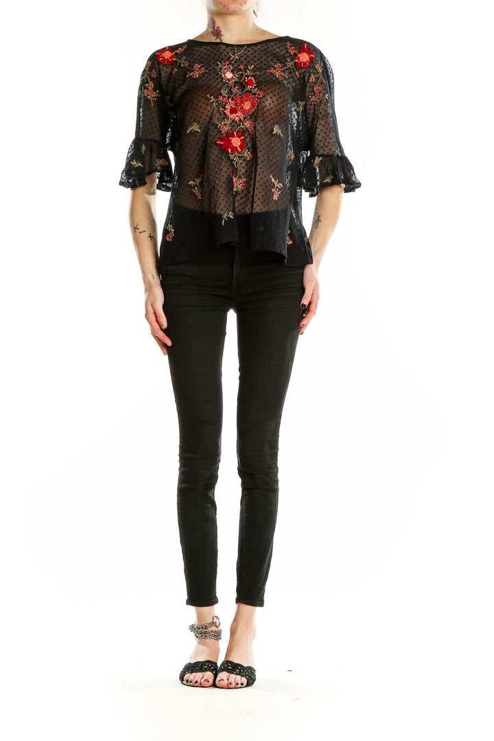 Front view of Maeve black sheer blouse with red floral embroidery and bell sleeves