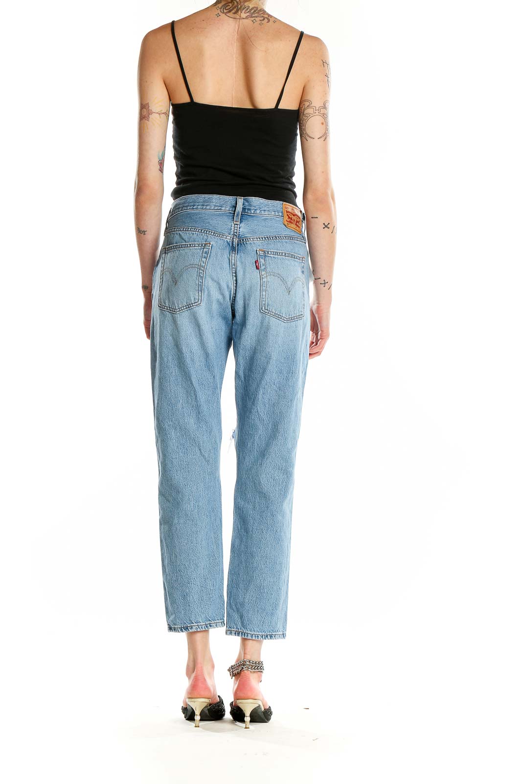 Back view of Levi's light blue distressed straight leg jeans on model