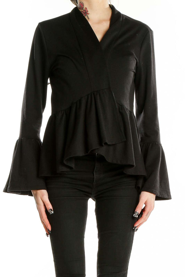 Front view of black peplum top with bell sleeves by Pebble and Stone