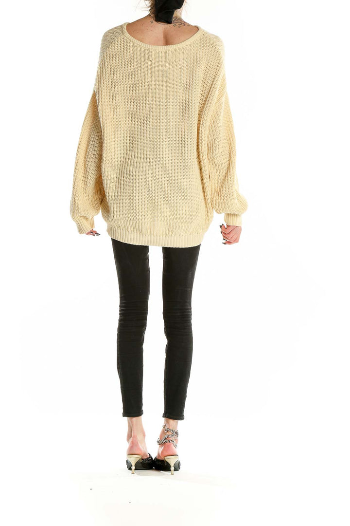 Back view of Margaux Lonnberg cream oversized ribbed cotton sweater showing high-low hemline