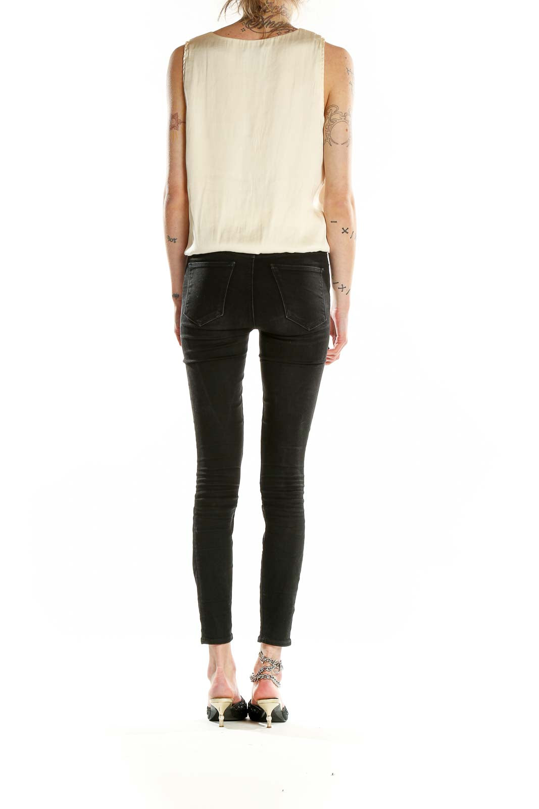 Back view of Sincerely Jules cream sleeveless blouse with black jeans