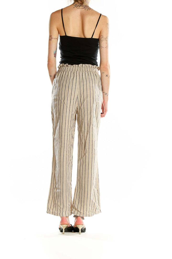 Back view of beige striped wide-leg cotton pants on model