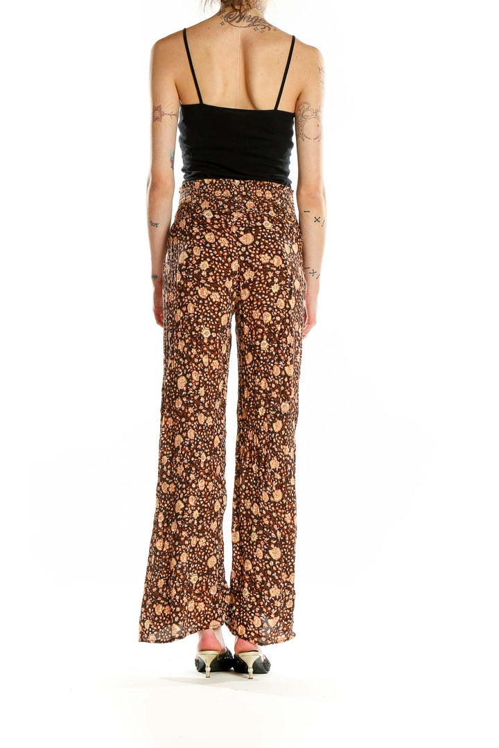 Back view of model wearing Billabong brown floral print wide-leg pants