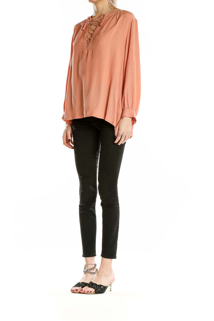 Front view of Madewell peach lace-up V-neck blouse