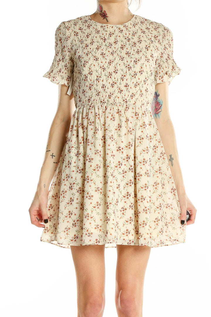 Front view of Sugar + Lips cream floral mini dress with smocked bodice and flutter sleeves