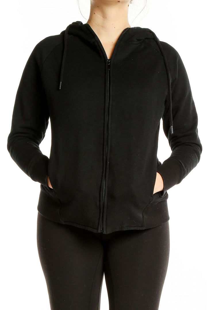 Front view of black Tavi Noir zip-up hoodie with hood and pockets