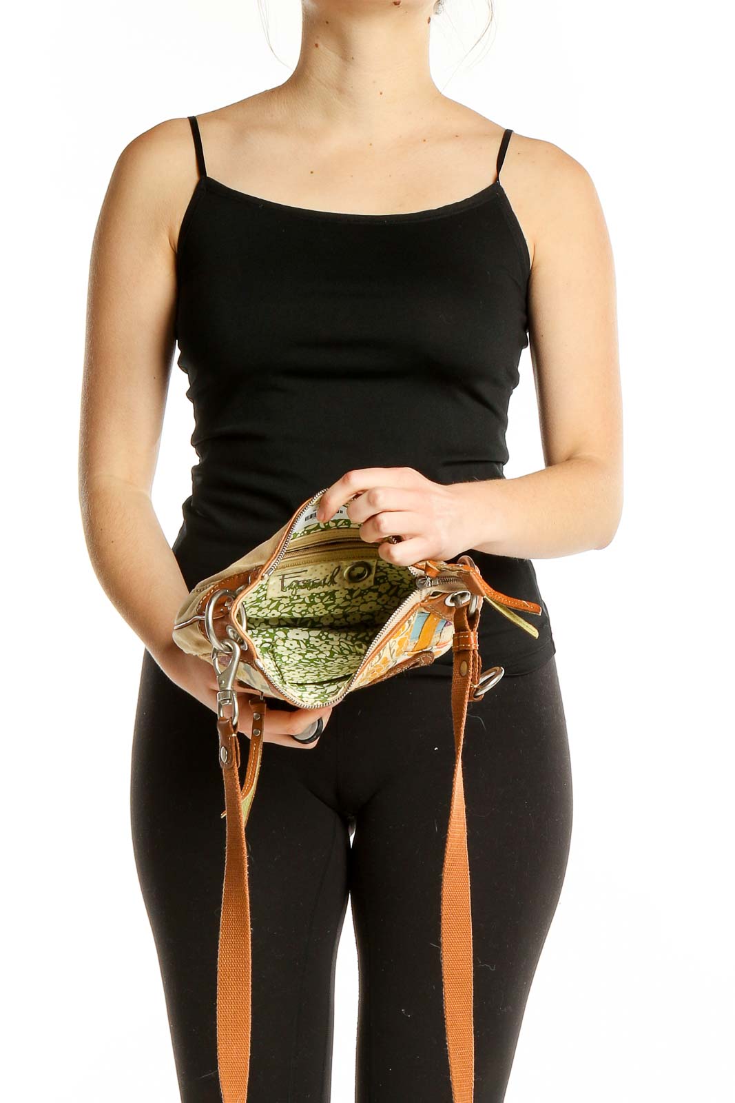 Model holding open Fossil patchwork shoulder bag, showing interior