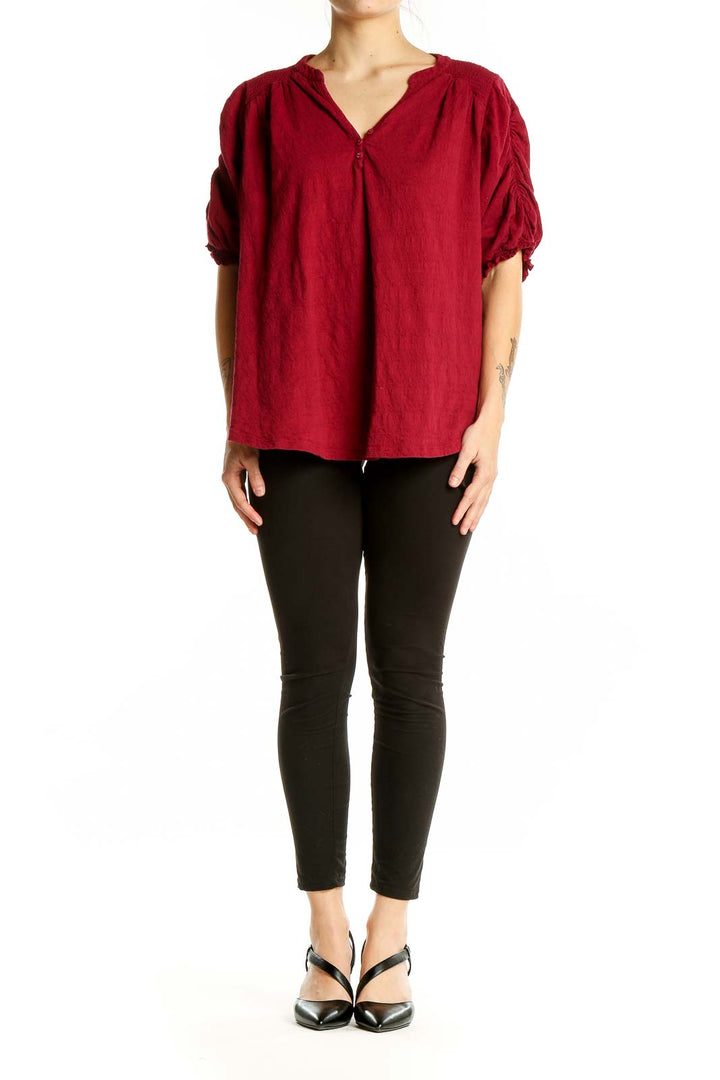 Front view of red Free People peasant blouse with ruched sleeves